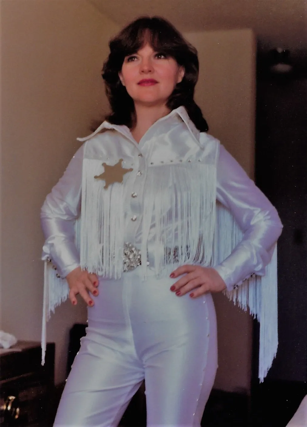 A woman in white outfit with star on chest.